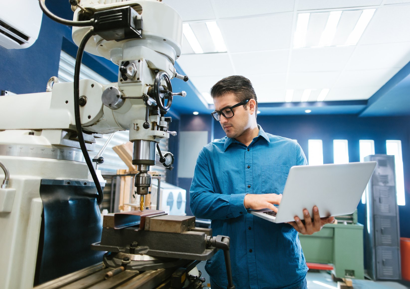 Young engineer calibrating large drill